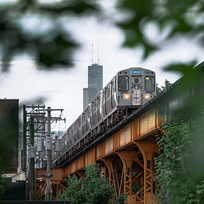 Chicago skyline and CTA train representing the multifamily market served by local real estate brokers